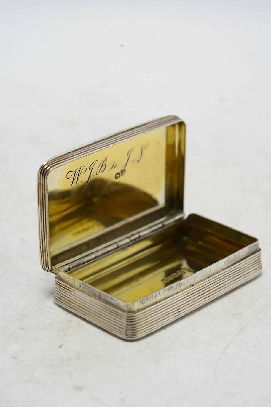 A late George III engine turned silver snuff box, William Elliot, London, 1819, 74mm, with interior engraved inscription. Condition - fair to good